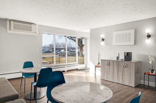 a living room with a table and chairs and a large window