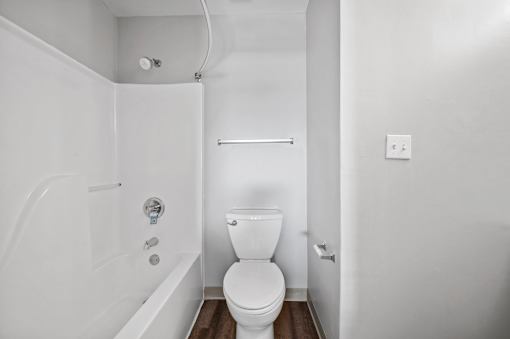 A white bathroom with a toilet, tub, and shower.