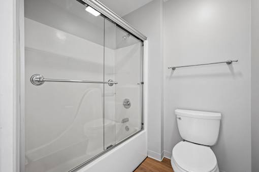 A white toilet in a bathroom with a walk-in shower.