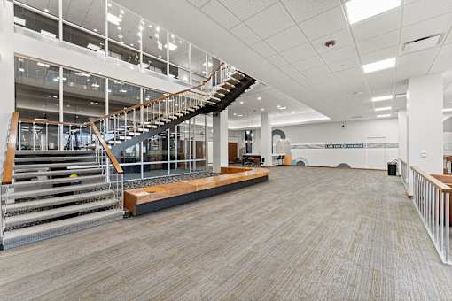 A spacious room with a staircase and a bench.