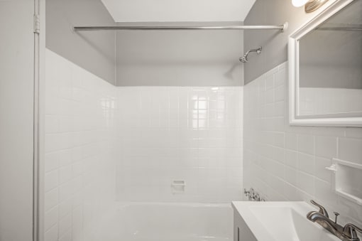 a white bathroom with a shower and a sink