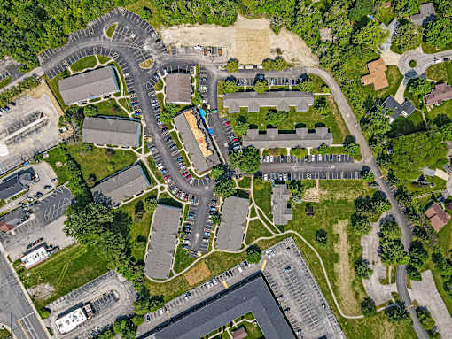 A bird's eye view of a residential area with houses, roads, and a parking lot. at Vivo Toledo Apartments, Toledo, OH, 43607