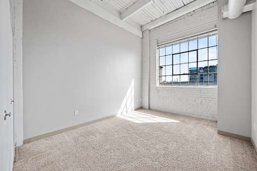 A room with a large window and a white door.