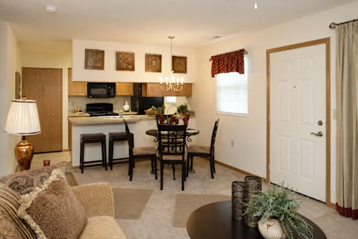 A well-lit living room with a dining table and chairs.