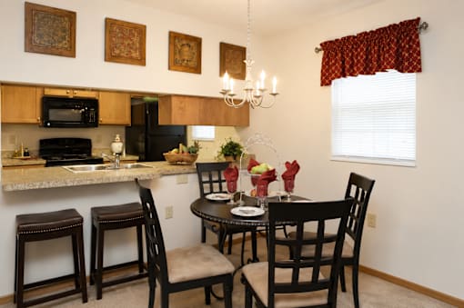 A kitchen with a table set for two.