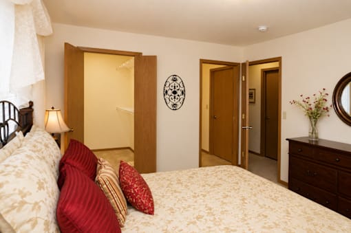 A bedroom with a bed, a dresser, and a mirror.