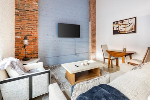 living room with a brick wall at Life At Agora, Cleveland, OH 44103  
