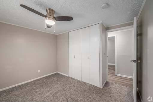 A room with a ceiling fan and a carpeted floor.