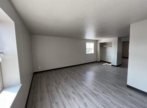A room with wooden flooring and white walls.