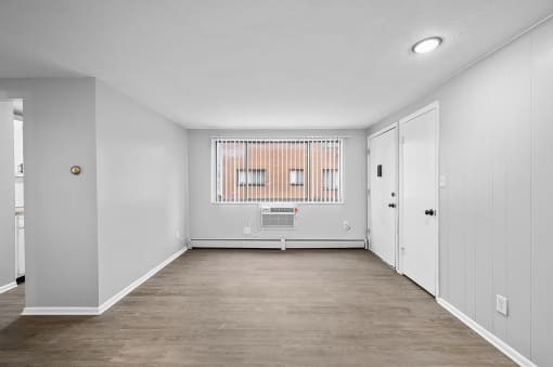 an empty room with white walls and a window