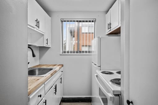 a kitchen with white appliances and a window