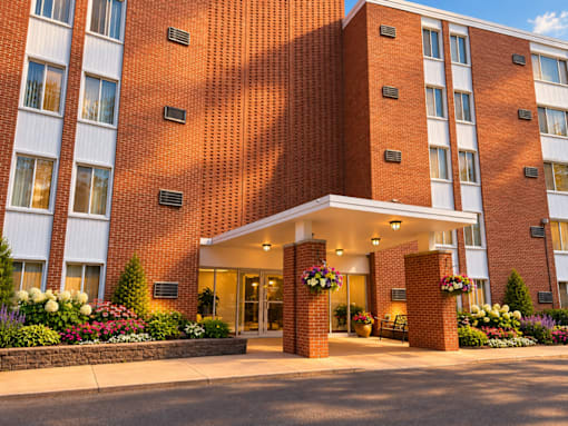 A red brick building with a white entrance and flower decorations.
