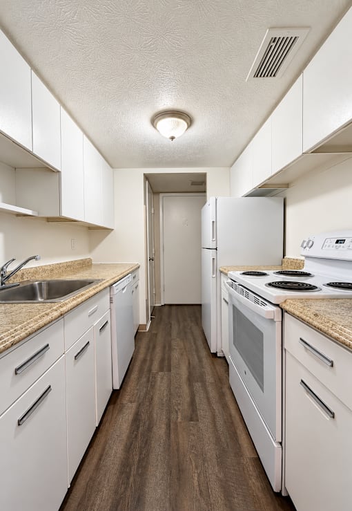 A kitchen with white cabinets and appliances.