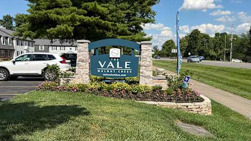 A sign for Vale Watercolor in front of a parking lot.