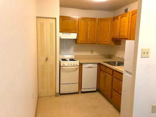 A kitchen with wooden cabinets and white appliances.