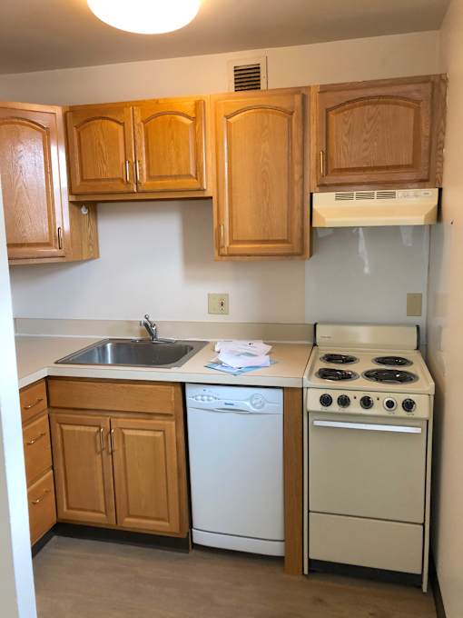 A small kitchen with a white dishwasher and a white stove.