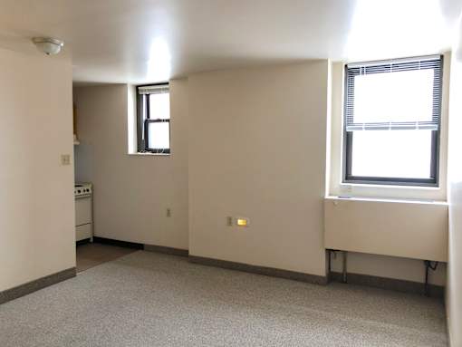 A small, empty room with a window on the right side.