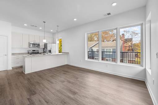 A kitchen with white cabinets and a wooden floor. at The Lumos Apartments, Cleveland