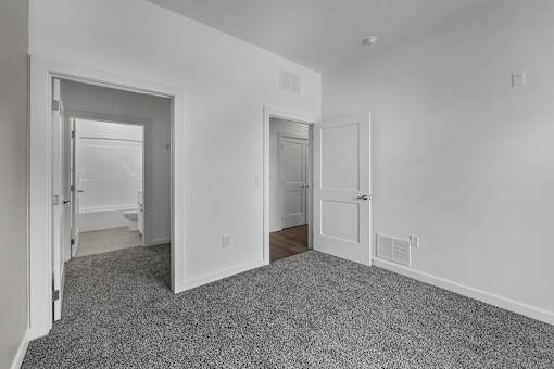 A room with two doors and a carpeted floor. at The Lumos Apartments, Cleveland, OH, 44106