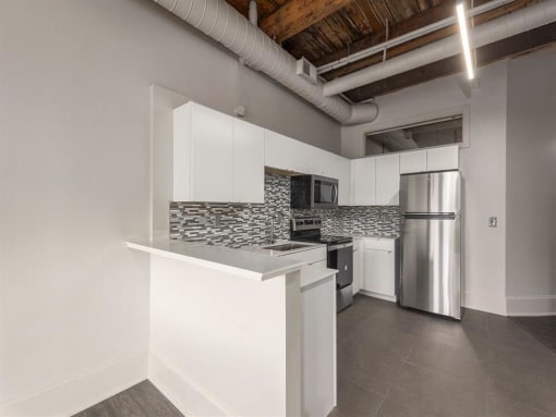 a kitchen with white cabinets and a stainless steel refrigerator