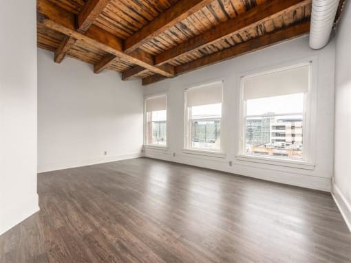 an empty room with white walls and a wooden ceiling