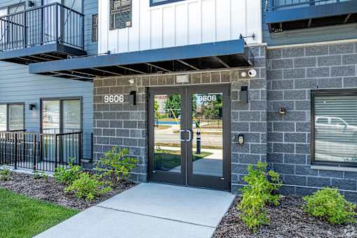 The image shows a modern building entrance with a glass door and a number plate above it. at Park Lamont Townhomes Apartments, Cleveland, OH, 44106