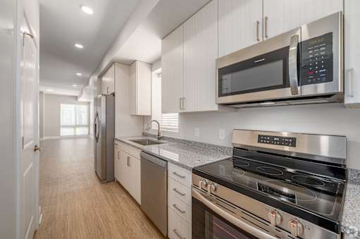 A modern kitchen with stainless steel appliances and wooden floors. at Park Lamont Townhomes Apartments, Cleveland