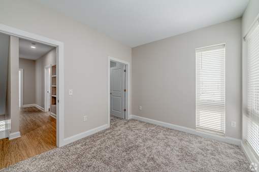 A room with a carpeted floor and a window with blinds. at Park Lamont Townhomes Apartments, Cleveland, Ohio