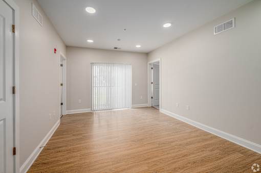 A large empty room with wooden floors and white walls. at Park Lamont Townhomes Apartments, Ohio