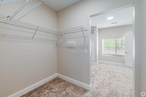 A room with a carpeted floor and a door leading to another room. at Park Lamont Townhomes Apartments, Cleveland 44106