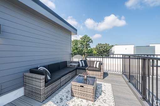 A patio with a couch and a table. at Park Lamont Townhomes Apartments, Ohio, 44106