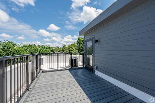 A balcony with a railing and a door leading to a house. at Park Lamont Townhomes Apartments, Ohio