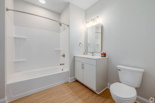 A white bathroom with a toilet, sink, and bathtub at Park Lamont Townhomes Apartments, Cleveland, Ohio