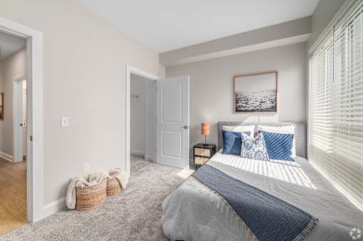 A bedroom with a large bed and a picture on the wall. at Park Lamont Townhomes Apartments, Cleveland, OH, 44106