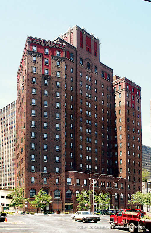 A red brick building with a parking lot in front.