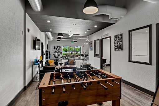 A room with a pool table and a foosball table. at Vivo Toledo Apartments, Toledo, OH, 43607