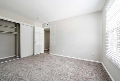 A room with a grey carpet and white walls.