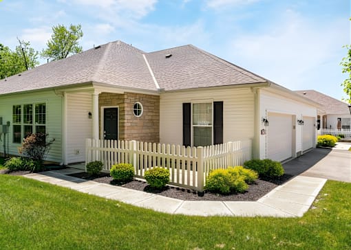 A house with a white picket fence in front.