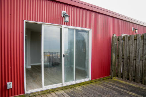 a red building with sliding glass doors and a deck