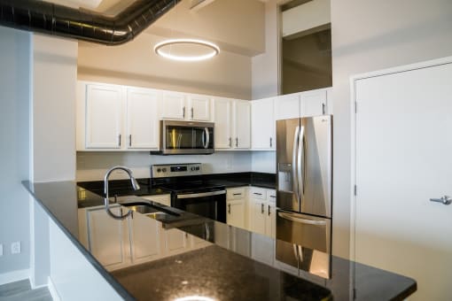a kitchen with black counter tops and stainless steel appliances