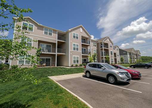 an apartment building with cars parked in a parking lot at The Bend, Lancaster, Ohio