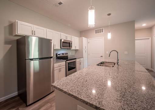 a kitchen with a granite counter top and stainless steel refrigerator at The Bend, Lancaster, OH, 43130