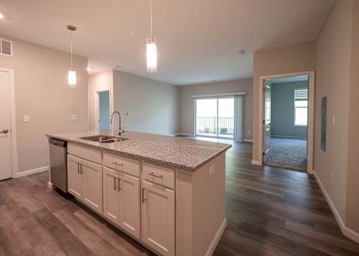 an empty kitchen with a sink and a counter top in a new home at The Bend, Lancaster