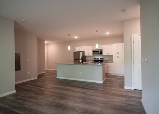 a kitchen and living room with white cabinets and a counter top at The Bend, Ohio, 43130