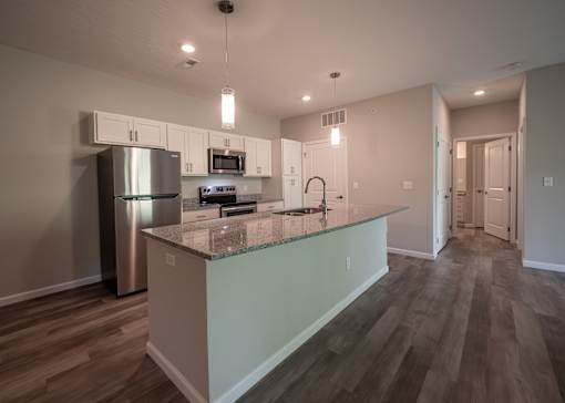 a kitchen with a large island and a stainless steel refrigerator at The Bend, Lancaster, Ohio