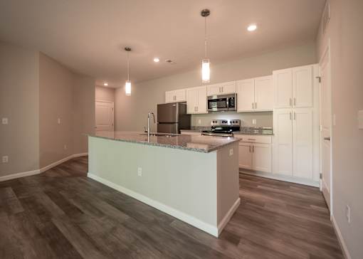 a kitchen with white cabinets and a large island in the middle at The Bend, Ohio, 43130