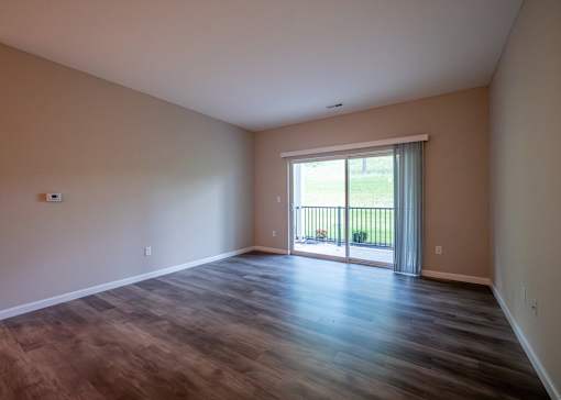 an empty living room with wooden floors and a sliding glass door at The Bend, Lancaster, OH, 43130