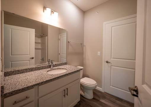 a bathroom with a toilet and a sink and a mirror at The Bend, Lancaster, Ohio