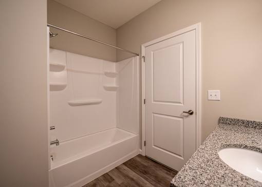 a bathroom with a sink and a shower and a white door at The Bend, Ohio, 43130