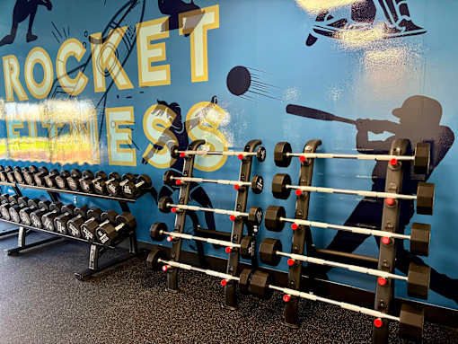 A gym wall with a rocket and a man lifting weights. at Vivo Toledo Apartments, Toledo, Ohio
